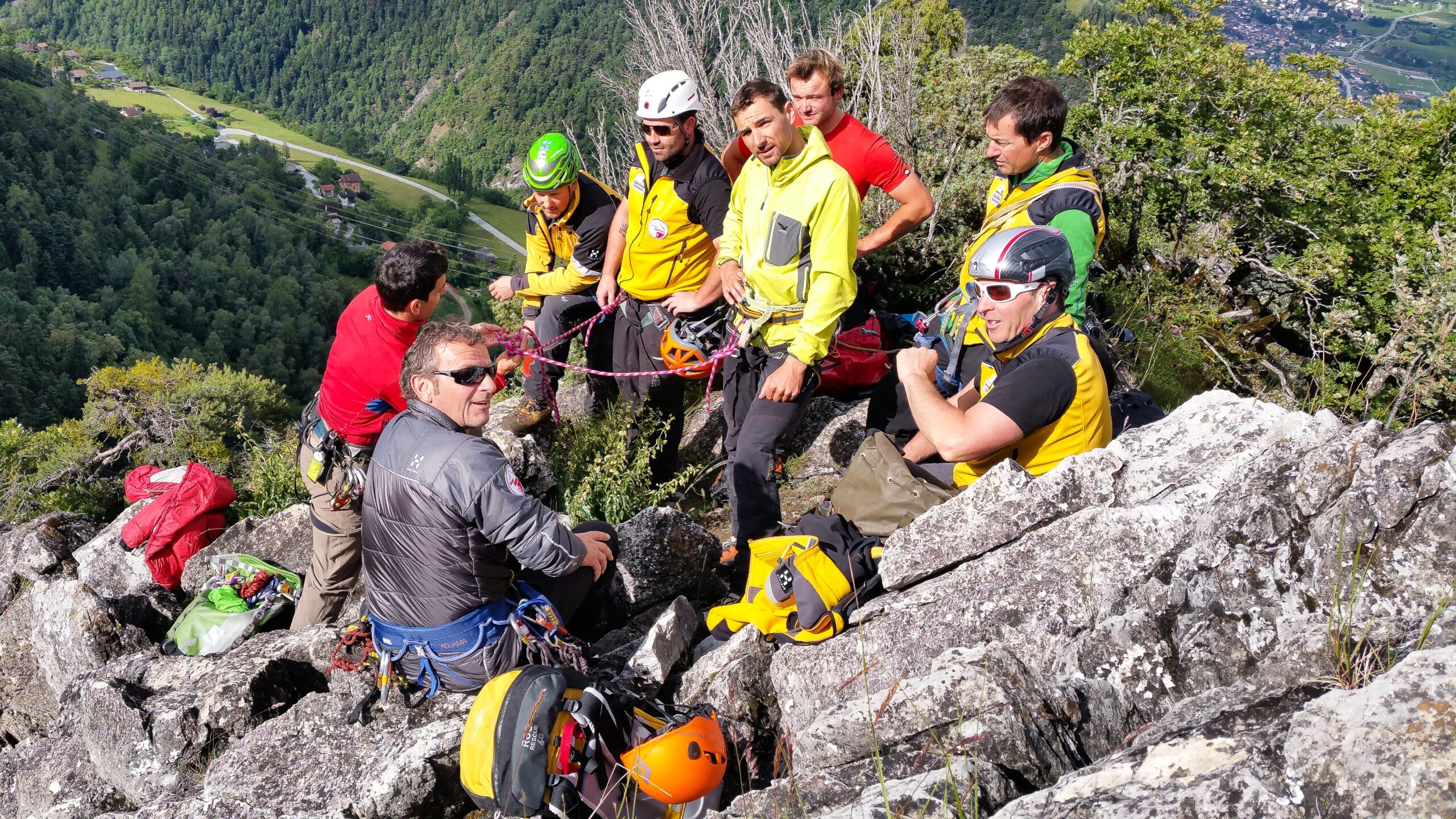 Groupe d'alpinistes équipés sur une crête rocheuse en montagne.