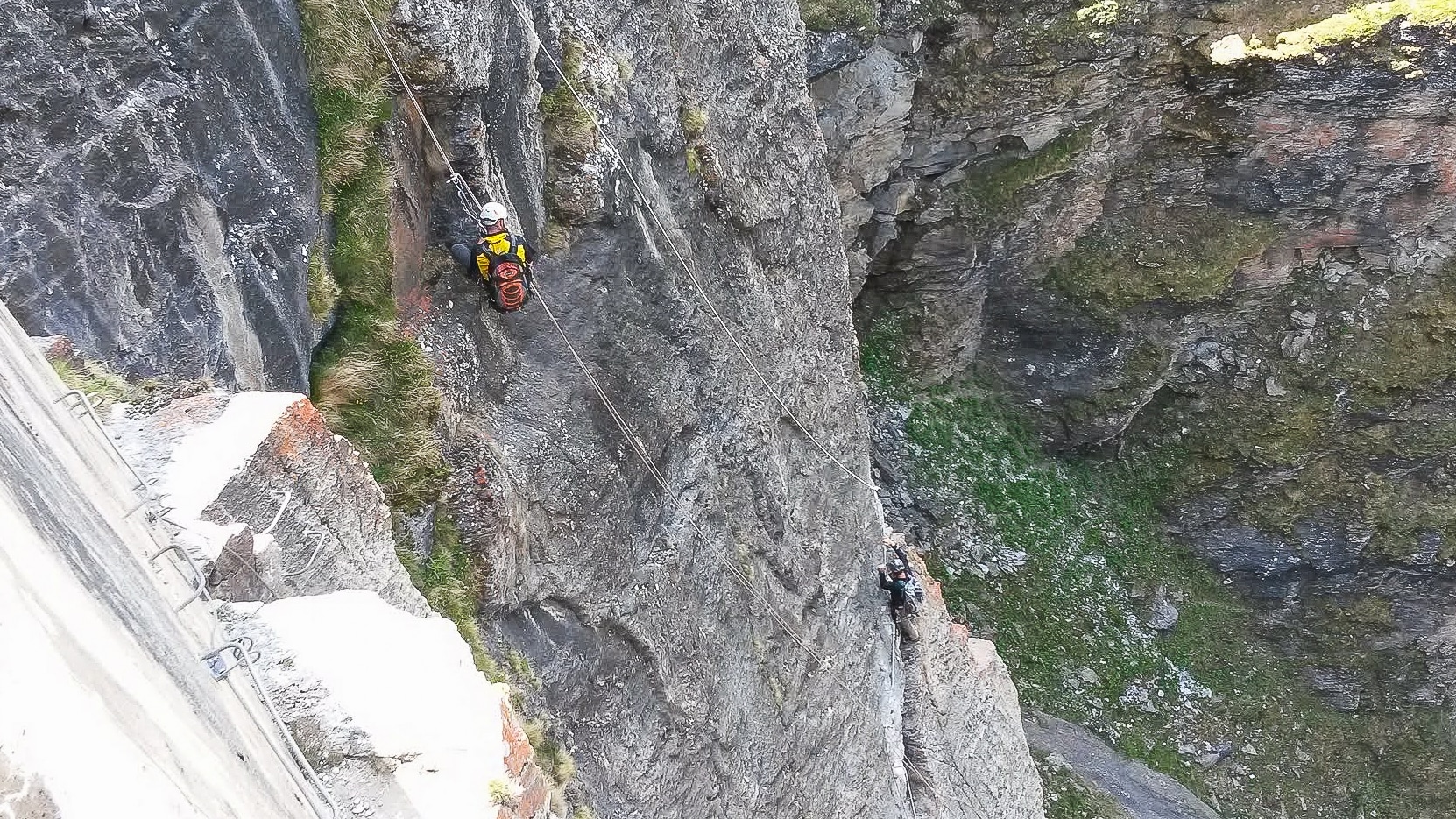 Deux techniciens sur corde inspectent paroi rocheuse et barrage.
